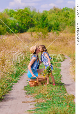 Girls sister in a field with a basket and flowers 17833838