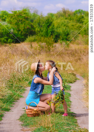 Girls sister in a field with a basket and flowers Girls sister in a field with a basket and flowers 17833839