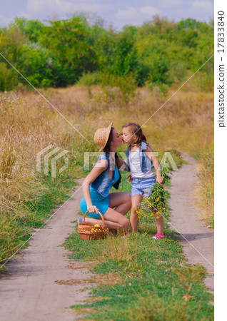 Girls sister in a field with a basket and flowers Girls sister in a field with a basket and flowers 17833840