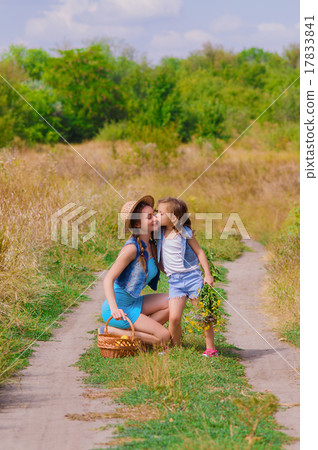 Girls sister in a field with a basket and flowers Girls sister in a field with a basket and flowers 17833841