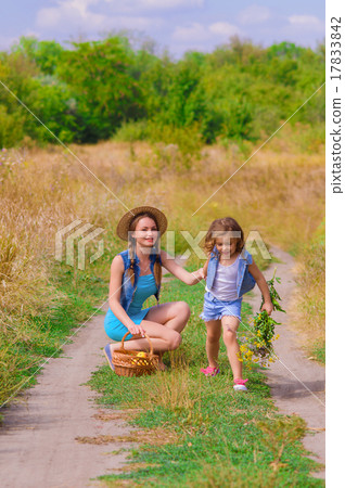 Girls sister in a field with a basket and flowers Girls sister in a field with a basket and flowers 17833842