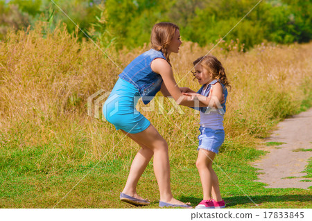 Girls sister in a field with a basket and flowers Girls sister in a field with a basket and flowers 17833845