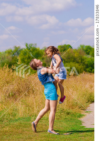 Girls sister in a field with a basket and flowers Girls sister in a field with a basket and flowers 17833846