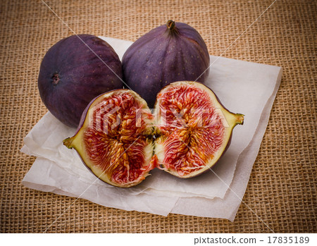 Three ripe figs on baking paper background Three ripe figs on baking paper background 17835189