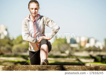 Young fit girl stretching out on bench before 17838245