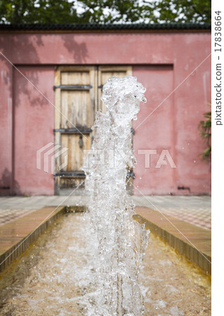 fountain in an oriental garden with red wall 17838664