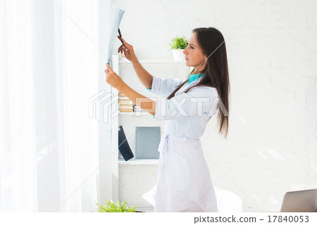 Young woman doctor watching a patient x-ray in 17840053