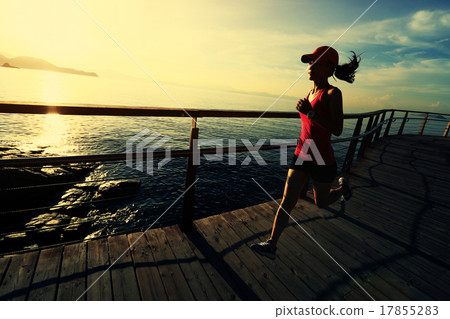 woman running on wooden boardwalk sunrise seaside 17855283