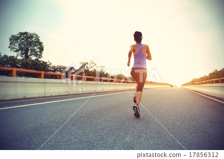 young woman runner running on city road young woman runner running on city road 17856312