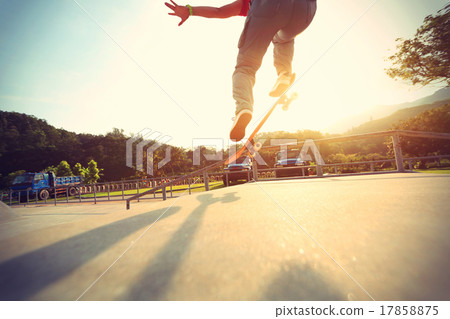 skateboarder legs doing a ollie at skatepark skateboarder legs doing a ollie at skatepark 17858875