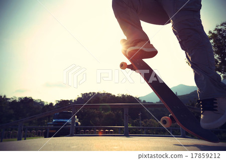 skateboarder legs doing a ollie at skatepark 17859212