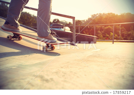 skateboarder legs riding skateboard at skatepark 17859217