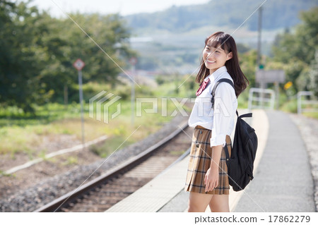 一個漂亮的學校女孩在車站回家等待火車 一個漂亮的學校女孩在車站回家等待火車 17862279