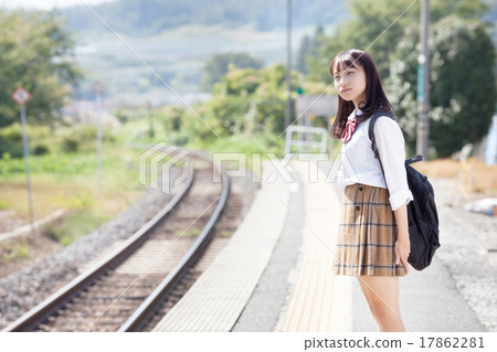 A pretty school girl who waits for a train at the station home 17862281