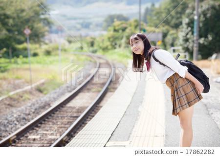 A pretty school girl who waits for a train at the station home A pretty school girl who waits for a train at the station home 17862282