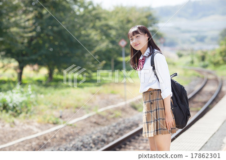 A pretty school girl who waits for a train at the station home 17862301