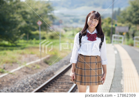A pretty school girl who waits for a train at the station home 17862309