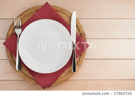 plate, knife and fork at cutting board on wood plate, knife and fork at cutting board on wood 17862550