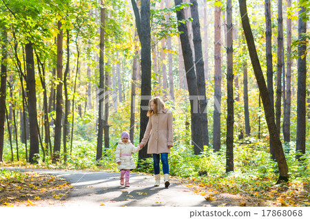 Mother and daughter walking in the autumn park 17868068