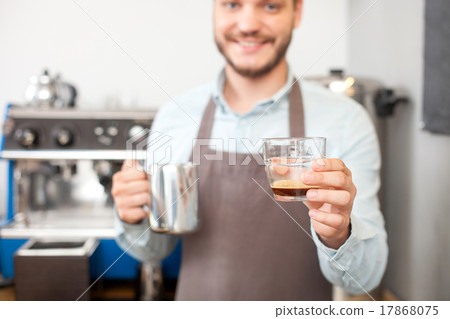 Handsome young barista is making coffee in 17868075