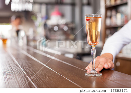 Professional male bartender is serving drink in Professional male bartender is serving drink in 17868171