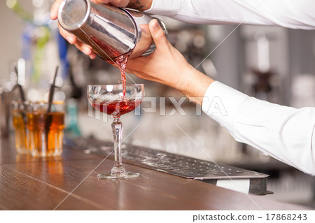 Professional male bartender is preparing drink in 17868243