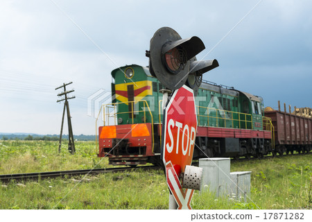 Railroad crossing signs and the approaching train Railroad crossing signs and the approaching train 17871282