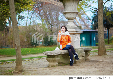 Woman with take-away coffee and croissant near the Eiffel tower 17871397