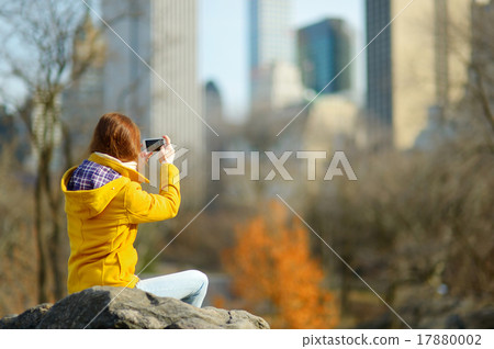 Beautiful young woman taking a photo of skyscapers Beautiful young woman taking a photo of skyscapers 17880002