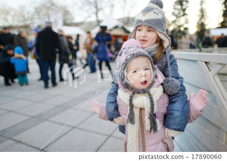 Two funny adorable little sisters outdoors in winter Two funny adorable little sisters outdoors in winter 17890060