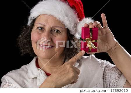Smiling Aged Woman Pointing at Red Gift. 17892010
