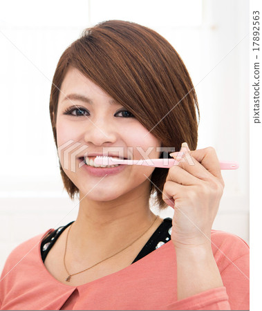 A young lady brushing up with a toothpaste 17892563