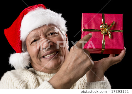 Male Senior Pointing At Red Wrapped Christmas Gift 17893131
