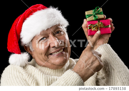 Smiling Senior Pointing At Two Wrapped Xmas Gifts 17893138