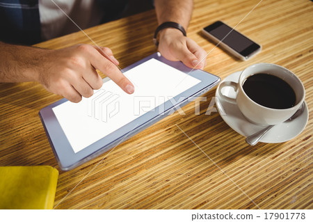 Young man having cup of coffee using tablet 17901778