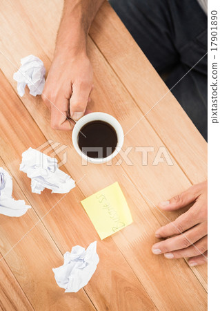 Hands holding coffee cup next to paper balls and sticky note Hands holding coffee cup next to paper balls and sticky note 17901890