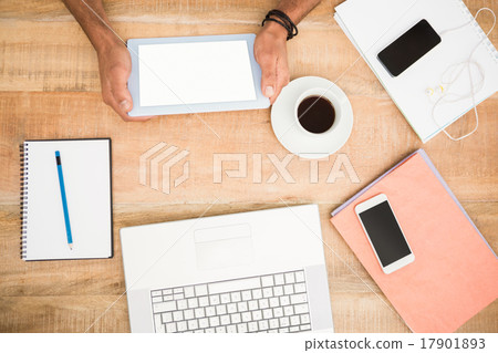 Hands holding tablet next to several devices Hands holding tablet next to several devices 17901893