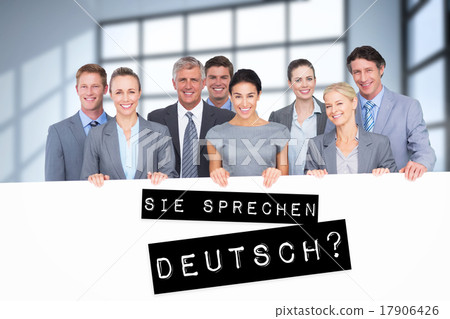 Composite image of smiling business team holding poster 17906426
