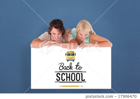 Composite image of cute smiling couple leaning on a whiteboard 17906470