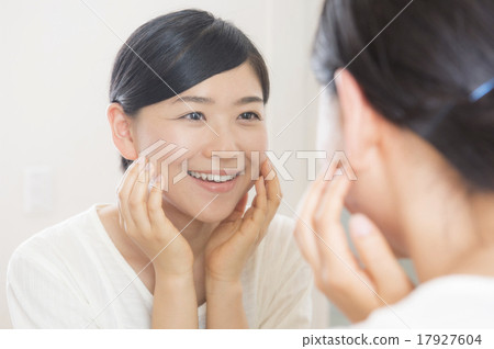 A woman in her 30s who has skin care through a mirror 17927604