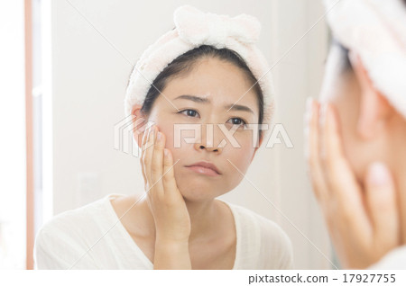 A woman who carries skin care through a mirror A woman who carries skin care through a mirror 17927755