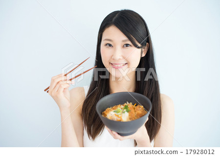 A woman eats pork cutlet 17928012