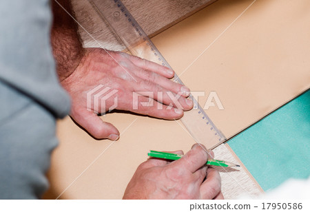 hand of a carpenter taking measurement of panels 17950586