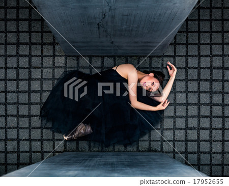ballerina lying on gray tiles between slabs 17952655