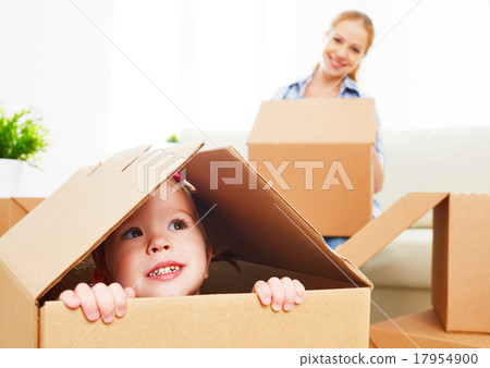 Stock Photo: happy family moves into a new apartment. happy baby in a cardboa