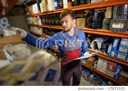 Worker on a automotive spare parts warehouse Worker on a automotive spare parts warehouse 17973315