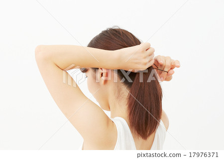 A woman tying her hair A woman tying her hair 17976371