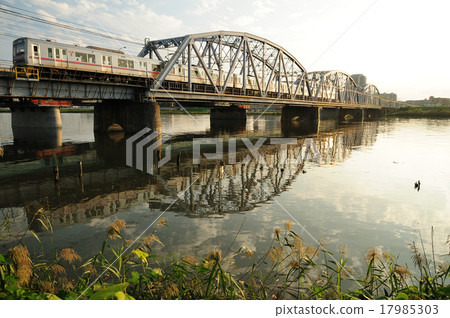 橫渡Horikiri橋樑的鐵橋樑的Keisei火車在日落 17985303