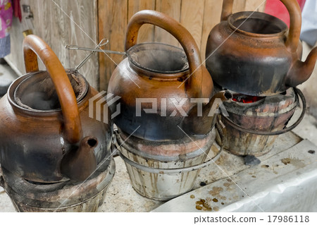 baked clay kettle with hot water on stove. 17986118