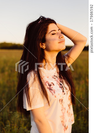 Girl straightens her hair back. 17986592